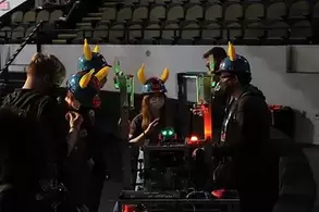 Picture of Red Raider Robotcs students wearng helmets with banana horns attached working on a robot